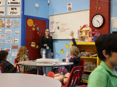 child raising their hand to ask a question to a counselor 